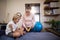 Female therapist showing electrical muscle stimulation machine to boy sitting on bed