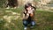 A female tourist drinks hot tea or coffee from a cup in the autumn garden by the fire. A girl is trembling in the open