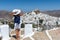 Female tourist enjoys the view to the white town of the island of Ios