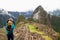 Female tourist gesturing a love sign to the famous ancient Inca ruins of Machu Picchu