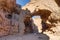 Female tourist hiking under Natural bridge, Death Valley NP