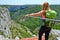 Female tourist looking at the zipline above Cikola canyon, in Croatia, while standing on the starting wooden platform.