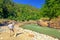 Female tourist looks down at a beautiful bend of the river White in Adygea