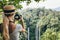 Female tourist photographing a waterfall in forest