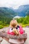 Female tourist sitting on the Queen Sony Chair at the Flydalsjuvet Viewpoint. The Geiranger village and Geirangerfjord landscape.