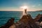 A female tourist, standing with her hands up, reaches the ends of the earth and sees the dragon rock. The girl welcomes