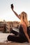 Female tourist taking mobile phone photo of Piazza di Spagna, landmark square with Spanish steps in Rome, Italy at