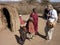 Female tourist talks to Masai children near village mud huts, Tanzania