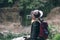 Female tourist use smartphone, take a photo. with backpack and cowboy hat looking at the river washed away the bridge, the