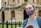 Female Tourist On Vacation Wearing Face Mask During Covid-19 Pandemic Reading Tourist Guide Book In Oxford UK