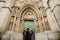 Female tourist visiting The Cathedral of Saint Mary of the See.Taking pictures with smartphone on the Door of Saint Miguel in