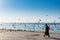 A female tourist wearing black hijab catching grey doves at the Jeddah Corniche coastal resort park near red sea in Jeddah,