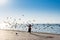 A female tourist wearing black hijab catching grey doves at the Jeddah Corniche coastal resort park near red sea in Jeddah,