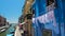 Female tourists go shopping in colorful street of Burano island in Venice Lagoon