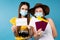 Female tourists with medical masks. Brunette with COVID-19 vaccine immunization card in front of camera. Blonde show flying
