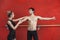 Female Trainer Assisting Male Ballet Dancer In Studio