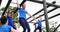 Female trainer clapping hands while fit people climbing monkey bars 4k