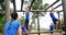 Female trainer clapping hands while fit people climbing monkey bars 4k