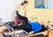 Female trainer controlling senior man doing pilates on reformer