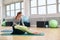 Female trainer helping senior woman doing yoga