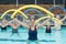 Female trainer and senior swimmers exercising with pool noodle