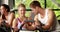 Female trainer talking to a man doing exercise bike