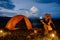 Female traveler or Backpacker sits by the camping stove near her tent, Enjoying the atmosphere of surrounding nature, Relaxation