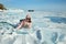 A female traveler behind a transparent ice floe of frozen Lake Baikal.