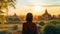 Female traveler photographing temples at Bagan Myanmar Asia at sunrise