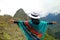 Female Traveler in Poncho Opening Arms to the Incredible Ancient Inca Citadel of Machu Picchu, Cusco, Peru