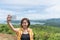 Female traveler selfie with her smart phone and beautiful landscape