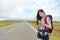 Female traveler standing on asphalt roadside