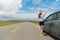 Female traveler stopping car on asphalt roadside