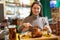 Female traveler tasting fried pork knuckle with beer in cafe