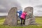 Female travelers having fun between two ancient volcanic rocks