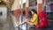 Female traveller using digital tablet while sitting on the floor at platform for waiting the train