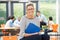 Female Tutor Sitting In Classroom With Folder