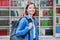 Female university student with backpack, inside library of educational building