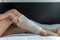 Female using put on elastic bandage with legs having knee or leg pain