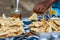 Female vendor selling fried pastry outdoors in the centre of Nosy Be, Madagascar