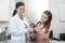 Female Vet Examining Weasel With Stethoscope Held By Girl