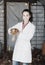 Female veterinarian in white coat holding brown chicken in hands