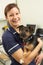 Female Veterinary Surgeon Holding Dog In Surgery