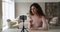 Female vlogger records videoblog talking looking at smartphone screen