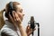 Female vocal recording. Young girl with microphone and headphones in recording studio. Recording of vocal, blogger, reading text,