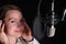 Female vocal recording. Young girl with microphone and headphones in recording studio. Recording of vocal, blogger, reading text,