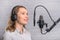 Female vocal recording. Young girl with microphone and headphones in recording studio. Recording of vocal, blogger, reading text,