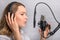 Female vocal recording. Young girl with microphone and headphones in recording studio. Recording of vocal, blogger, reading text,