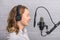 Female vocal recording. Young girl with microphone and headphones in recording studio. Recording of vocal, blogger, reading text,