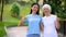 Female volunteer and elderly woman showing thumbs up, social support project